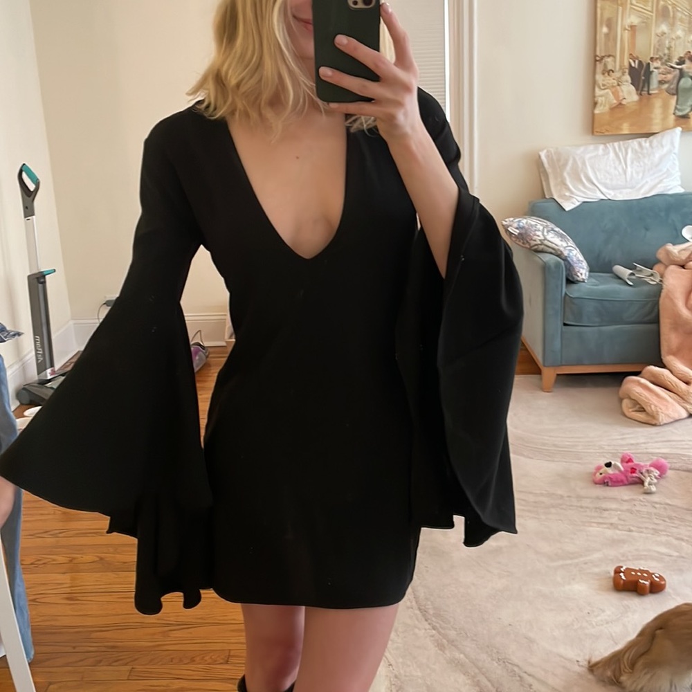 Plunge neckline black dress with exaggerated bell sleeves